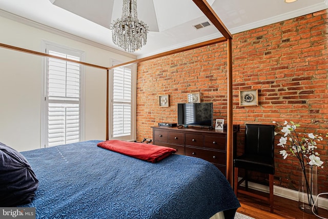 bedroom featuring a chandelier, wood finished floors, brick wall, ornamental molding, and baseboards