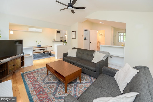 living area featuring a wall mounted air conditioner, ceiling fan, vaulted ceiling, and wood finished floors