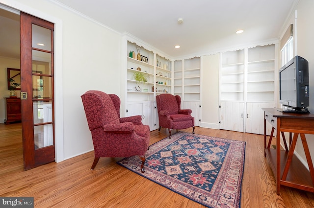 living area featuring wood finished floors, ornamental molding, built in features, and recessed lighting