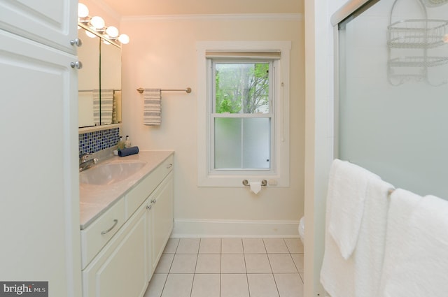 bathroom with tile patterned floors, crown molding, backsplash, vanity, and baseboards