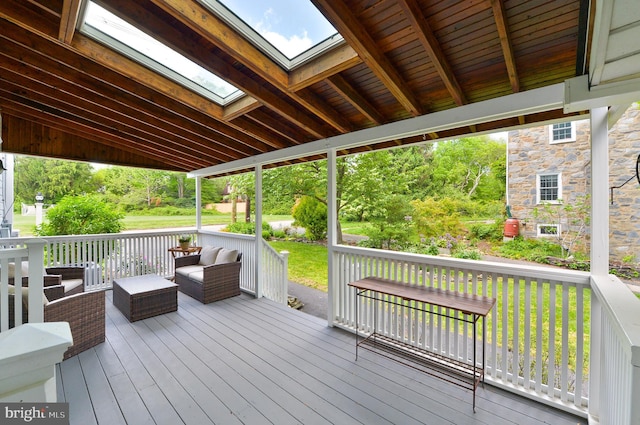 wooden deck with an outdoor living space and a yard