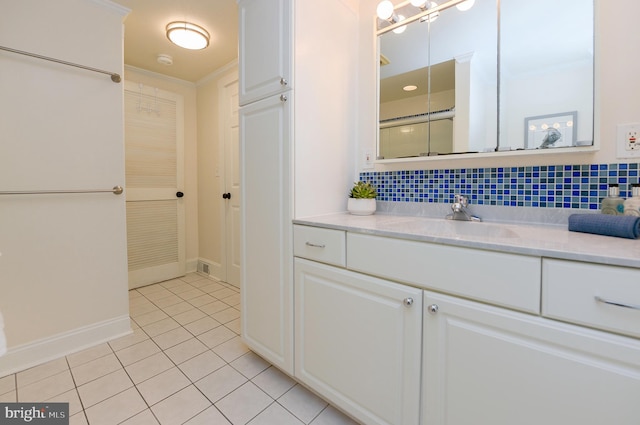 bathroom with tile patterned flooring, decorative backsplash, vanity, baseboards, and crown molding