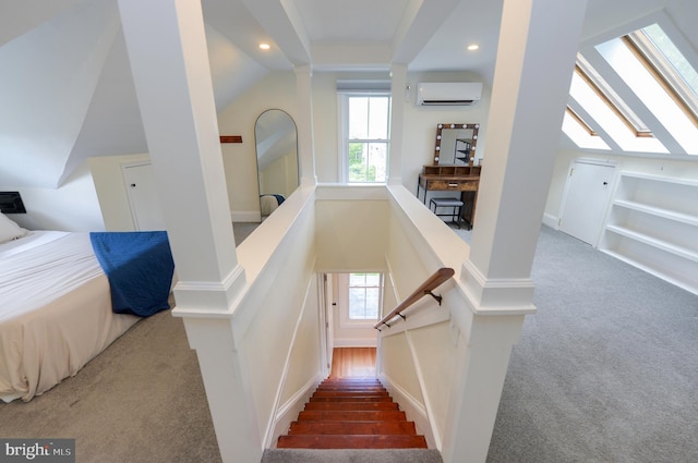 stairs with a wall mounted air conditioner, carpet floors, vaulted ceiling, plenty of natural light, and recessed lighting