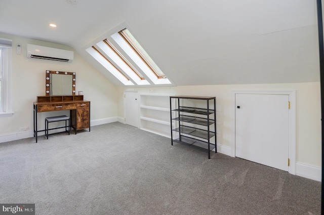 additional living space featuring a skylight, a wall mounted air conditioner, carpet, vaulted ceiling, and baseboards