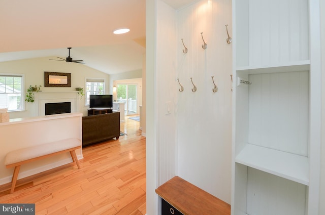 mudroom with light wood finished floors, a fireplace, a ceiling fan, and vaulted ceiling