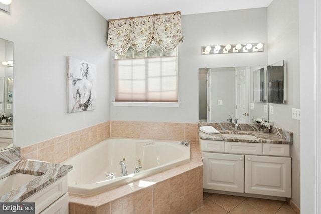 full bathroom featuring tile patterned flooring, a tub with jets, and two vanities