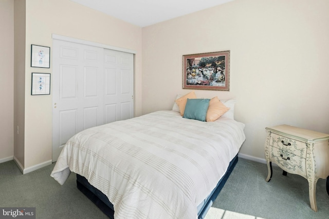 carpeted bedroom with a closet and baseboards