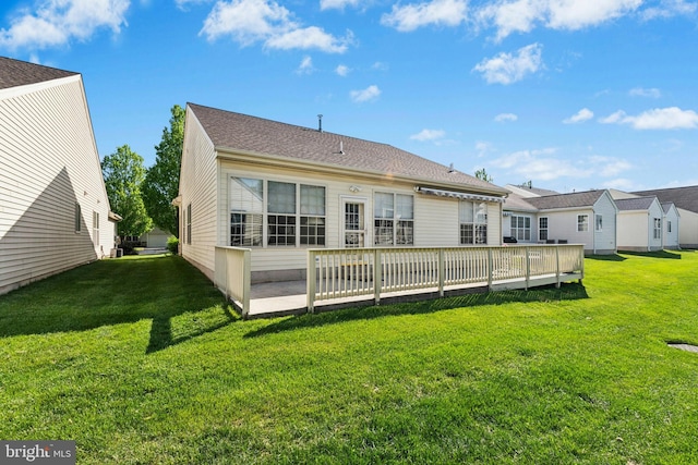 rear view of property with a yard and a wooden deck