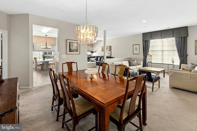 dining space featuring a chandelier, light colored carpet, and recessed lighting