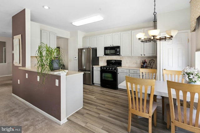 kitchen with black appliances, a chandelier, backsplash, light countertops, and recessed lighting