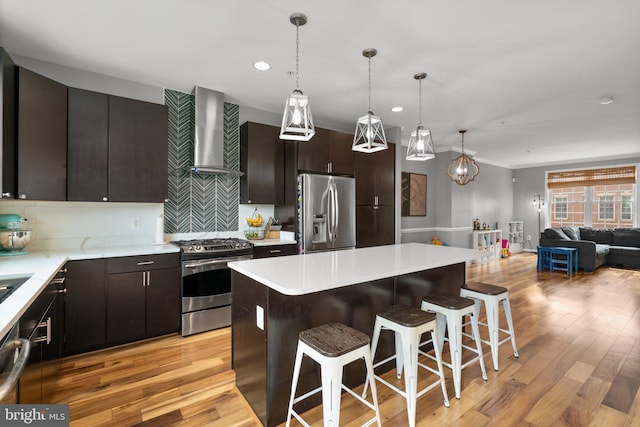 1338 Lowman St, Baltimore, MD 21230 - kitchen featuring stainless steel appliances, wall chimney exhaust hood, a breakfast bar area, open floor plan, and light countertops