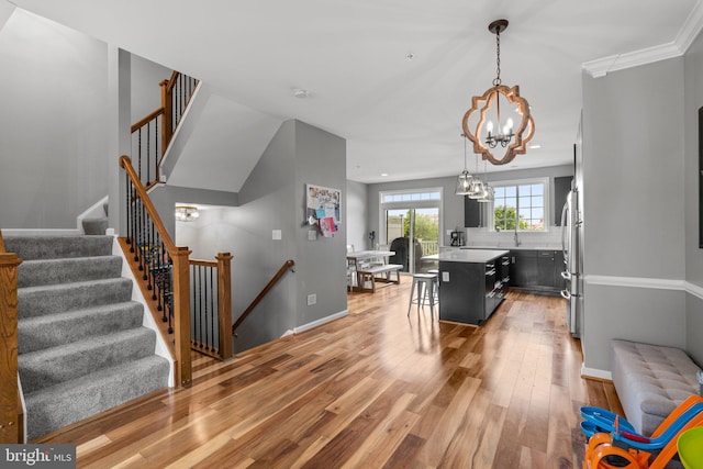 1338 Lowman St, Baltimore, MD 21230 - kitchen featuring a chandelier, light wood-style flooring, a center island, a kitchen breakfast bar, and light countertops