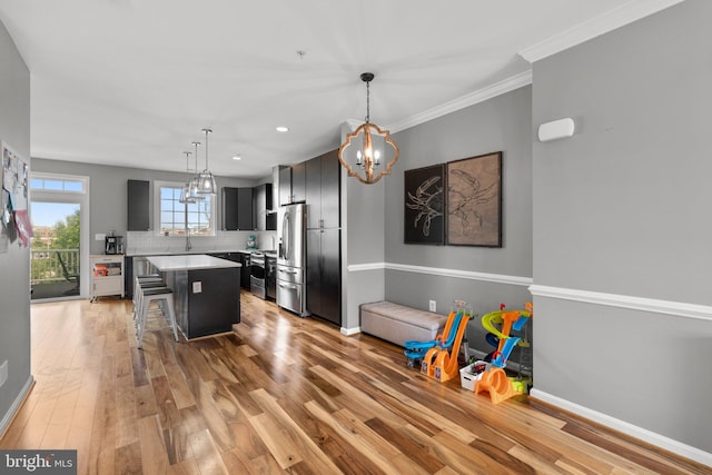 1338 Lowman St, Baltimore, MD 21230 - kitchen featuring stainless steel appliances, a kitchen bar, a chandelier, light wood-style floors, and a kitchen island