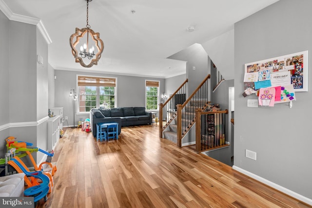 1338 Lowman St, Baltimore, MD 21230 - living room featuring wood finished floors, a chandelier, crown molding, baseboards, and stairway