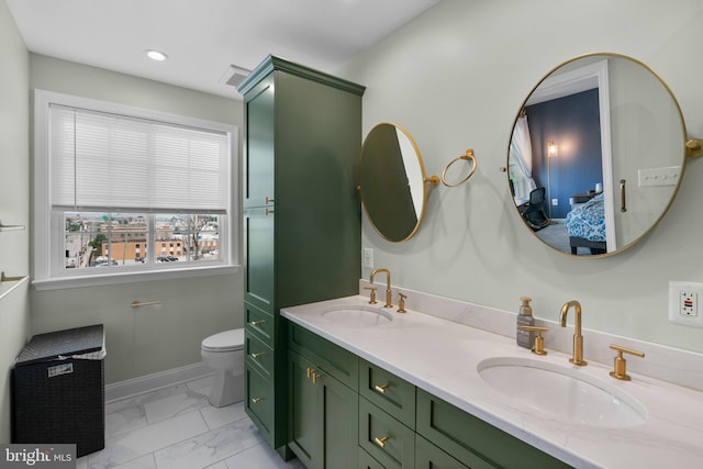 1338 Lowman St, Baltimore, MD 21230 - ensuite bathroom with marble look tiles, double vanity, toilet, baseboards, and recessed lighting