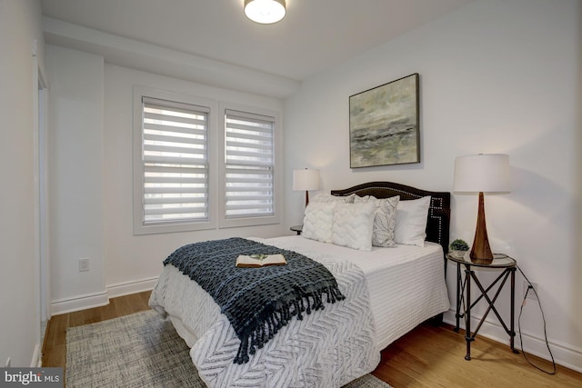 bedroom with wood finished floors and baseboards