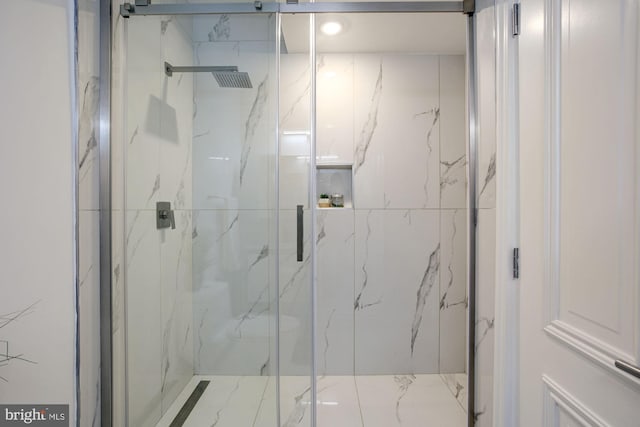 bathroom with a marble finish shower