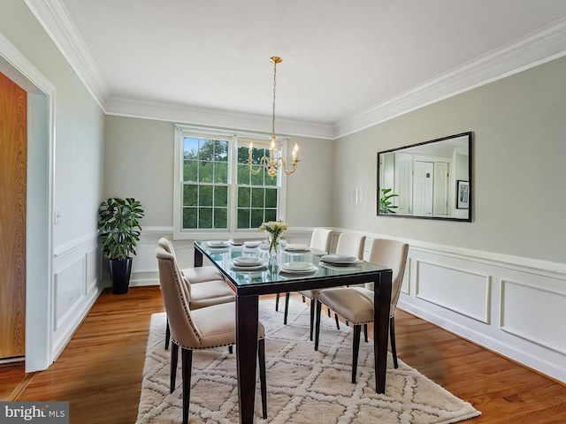 16028 Kings Mountain Rd, Woodbridge, VA 22191 - dining room with crown molding, a chandelier, wood finished floors, a decorative wall, and a wainscoted wall