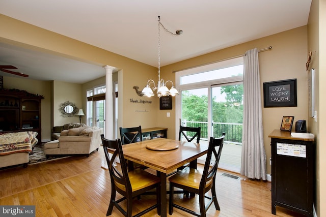 8931 Kiger St, Lorton, VA 22079 - dining room with light wood-style flooring, a chandelier, and decorative columns