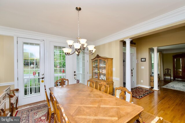 8931 Kiger St, Lorton, VA 22079 - dining room featuring ornate columns, crown molding, wood finished floors, a chandelier, and baseboards