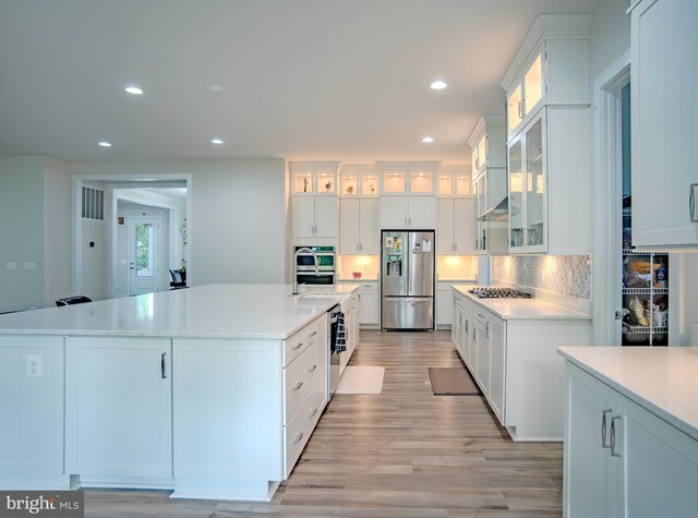 23883 Ebony Eyes Ct, Aldie, VA 20105 - kitchen featuring appliances with stainless steel finishes, recessed lighting, light wood finished floors, light countertops, and white cabinets