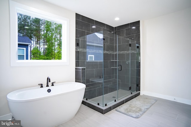 23883 Ebony Eyes Ct, Aldie, VA 20105 - full bath featuring a shower stall, a freestanding tub, baseboards, and tile patterned flooring
