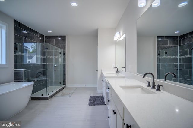 23883 Ebony Eyes Ct, Aldie, VA 20105 - bathroom featuring double vanity, a shower stall, recessed lighting, a freestanding tub, and baseboards