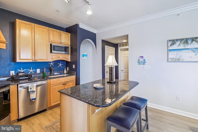 105 56th Unit 210P1, Ocean City, MD 21842 - kitchen with stainless steel appliances, light brown cabinets, light wood-style flooring, a sink, and a breakfast bar