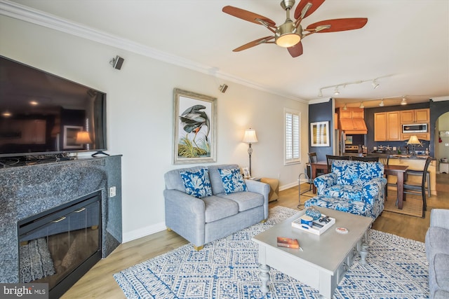 105 56th Unit 210P1, Ocean City, MD 21842 - living room featuring crown molding, light wood-style flooring, a ceiling fan, baseboards, and a glass covered fireplace