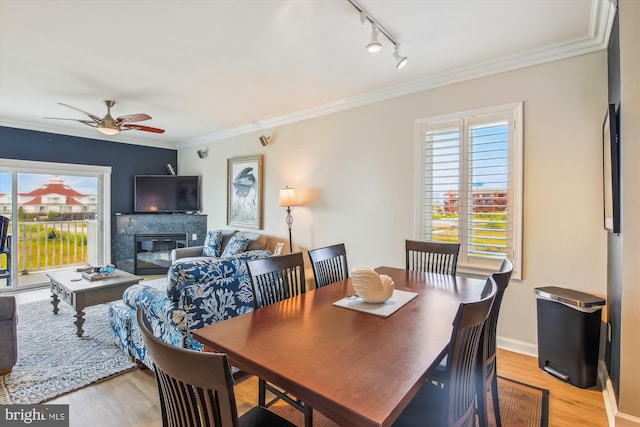 105 56th Unit 210P1, Ocean City, MD 21842 - dining space with light wood finished floors, track lighting, a ceiling fan, crown molding, and a glass covered fireplace
