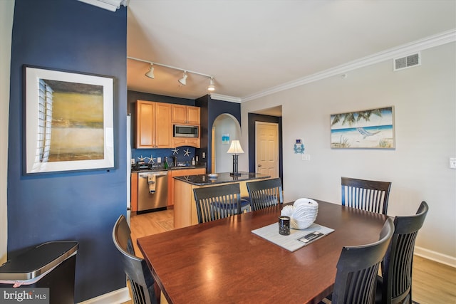 105 56th Unit 210P1, Ocean City, MD 21842 - dining area with rail lighting, arched walkways, light wood-type flooring, baseboards, and crown molding