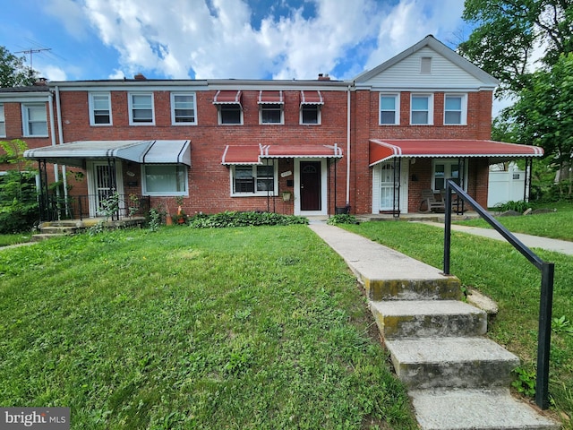 townhome / multi-family property featuring brick siding and a front lawn
