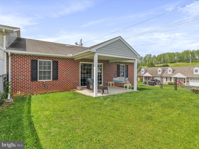 rear view of property with brick siding, a patio area, and a shingled roof