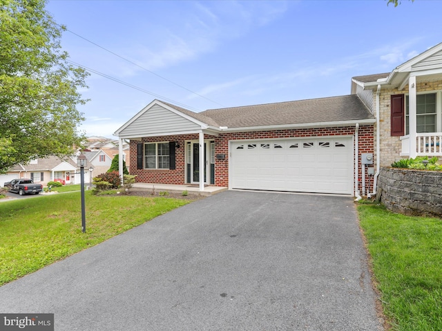 view of front facade with an attached garage, brick siding, driveway, and a front yard