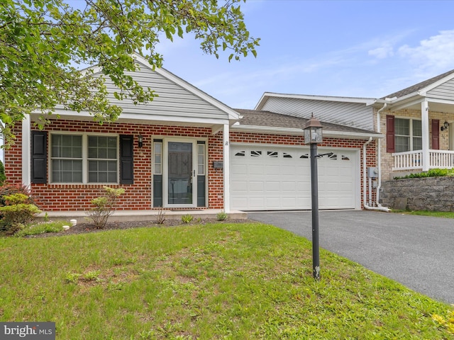 view of front of house featuring a garage, brick siding, driveway, and a front lawn