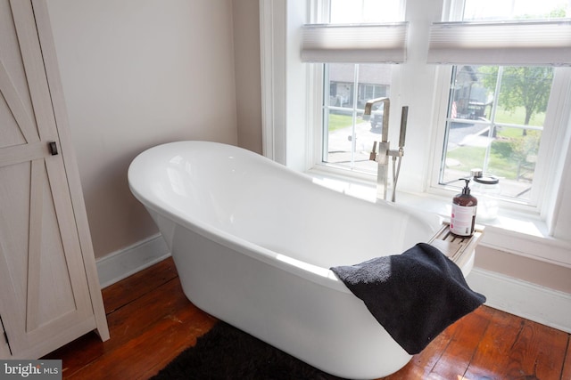 644 Early Dr, Broadway, VA 22815 - bathroom featuring hardwood / wood-style floors, a freestanding tub, and baseboards