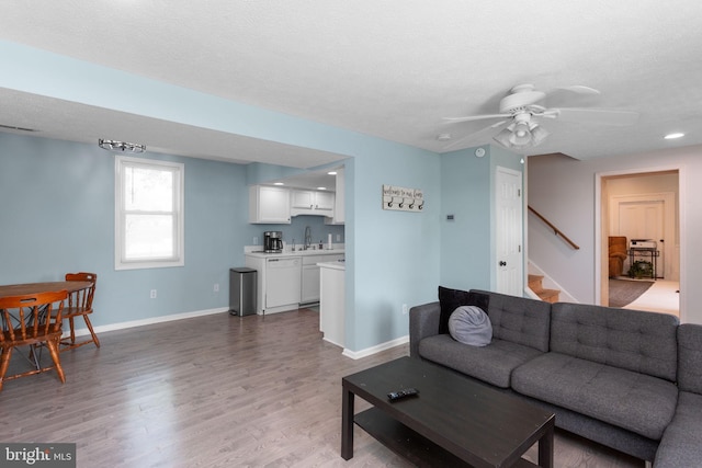 644 Early Dr, Broadway, VA 22815 - living area with ceiling fan, light wood-type flooring, baseboards, stairs, and a textured ceiling