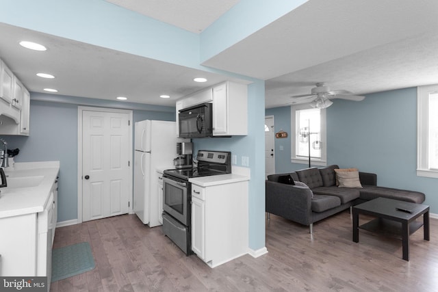 644 Early Dr, Broadway, VA 22815 - kitchen with stainless steel electric stove, black microwave, a sink, light wood-style floors, and white cabinetry