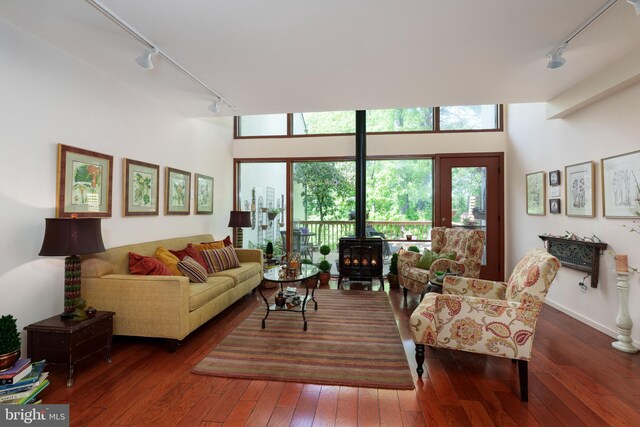 living area featuring track lighting, hardwood / wood-style floors, and a wood stove