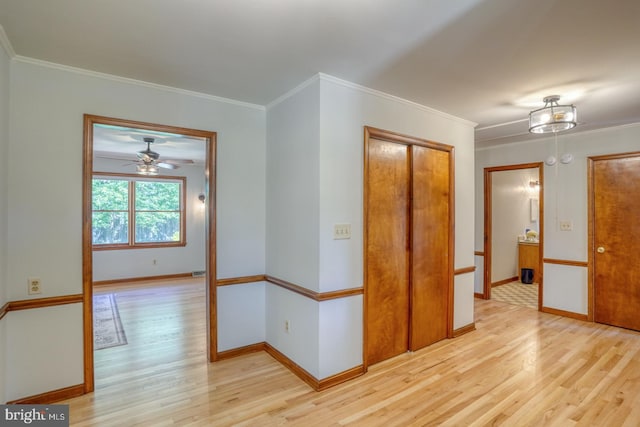 unfurnished room featuring light wood finished floors, ornamental molding, baseboards, and ceiling fan