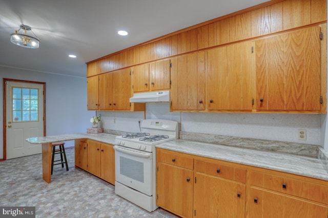 kitchen with white gas range oven, under cabinet range hood, light countertops, recessed lighting, and light flooring