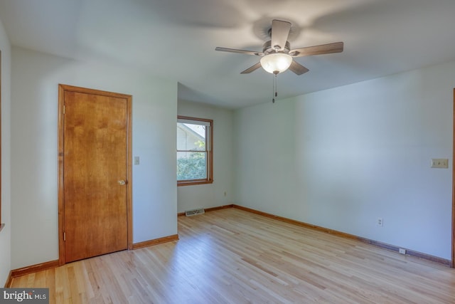 spare room featuring light wood-type flooring, ceiling fan, and baseboards