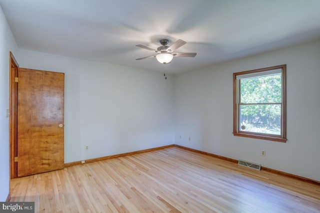 unfurnished room with a ceiling fan, light wood-type flooring, and baseboards