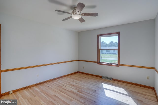 unfurnished room with wood finished floors, baseboards, and a ceiling fan