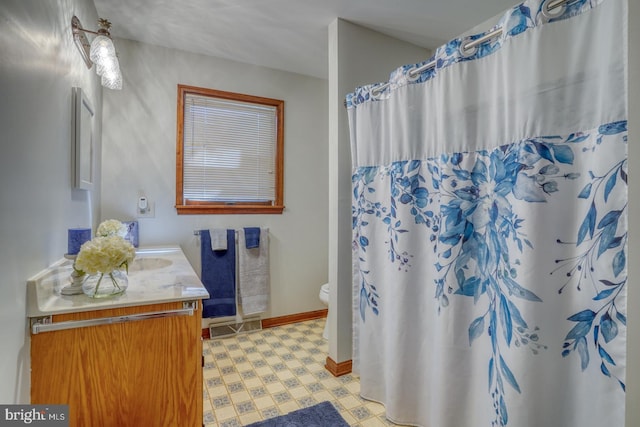 bathroom featuring tile patterned floors, vanity, toilet, baseboards, and a shower with shower curtain