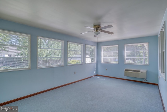 unfurnished room featuring a wall mounted air conditioner, a ceiling fan, carpet flooring, and baseboards