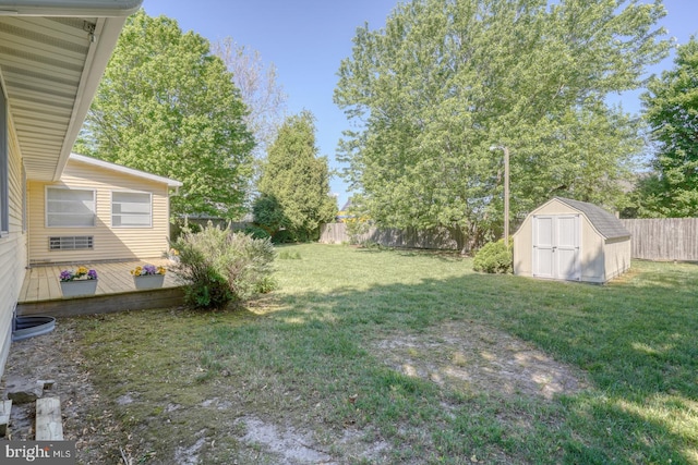view of yard with a storage shed, an outbuilding, and a deck