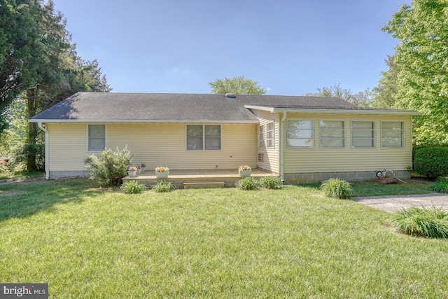 view of front facade with a front yard and roof with shingles