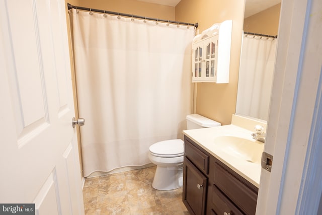 bathroom with toilet, vanity, and curtained shower