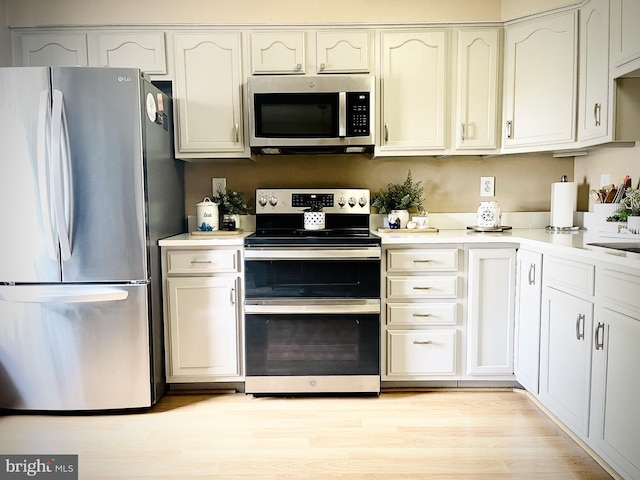 kitchen featuring appliances with stainless steel finishes, light countertops, and light wood-style flooring